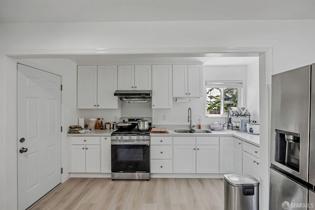 2675 Simas Ave, Pinole, CA 94564 - kitchen with stainless steel appliances, under cabinet range hood, light wood-type flooring, white cabinets, and light countertops