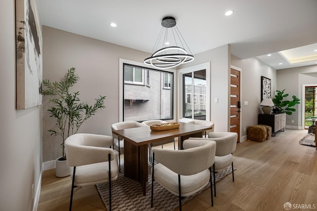 dining area featuring light wood finished floors, baseboards, a chandelier, and recessed lighting