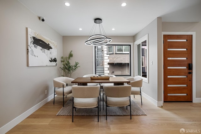 dining space with a chandelier, baseboards, recessed lighting, and light wood-style floors