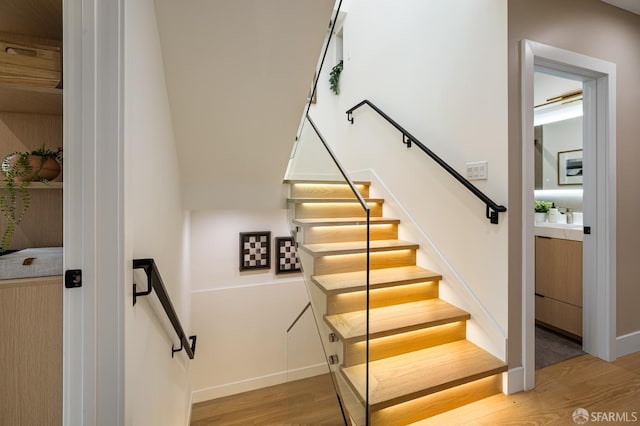stairway featuring wood finished floors and baseboards