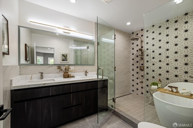 bathroom with tile walls, a freestanding tub, a stall shower, tile patterned flooring, and recessed lighting