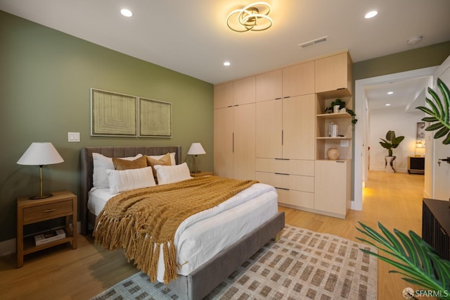 bedroom with light wood finished floors and recessed lighting