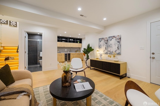 living room featuring light wood-style flooring, wine cooler, recessed lighting, and baseboards
