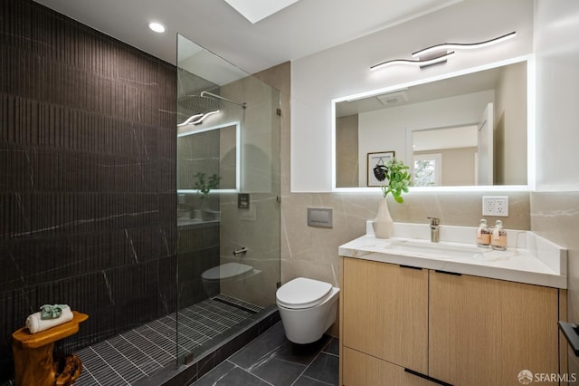 bathroom featuring tile patterned flooring, walk in shower, toilet, tile walls, and vanity