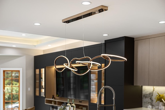 kitchen view of modern cabinets, a chandelier, and recessed lighting