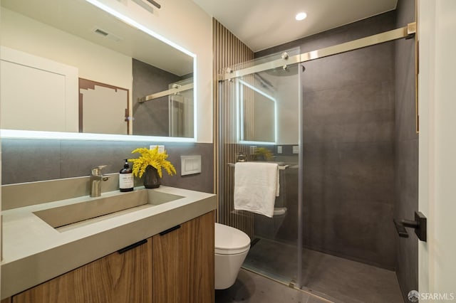full bath featuring toilet, a stall shower, and vanity