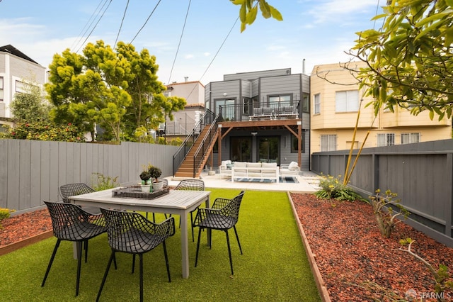 rear view of property featuring an outdoor living space, a fenced backyard, stairway, a patio area, and outdoor dining space