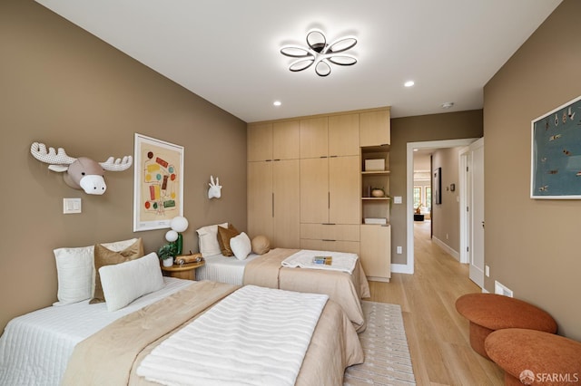 bedroom featuring light wood finished floors, recessed lighting, and baseboards