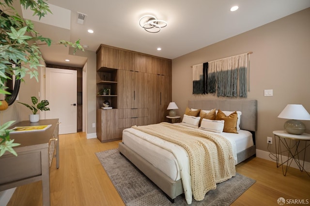 bedroom with light wood-style flooring, baseboards, and recessed lighting