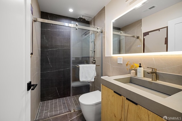 full bathroom with toilet, a shower stall, tile walls, vanity, and tile patterned flooring