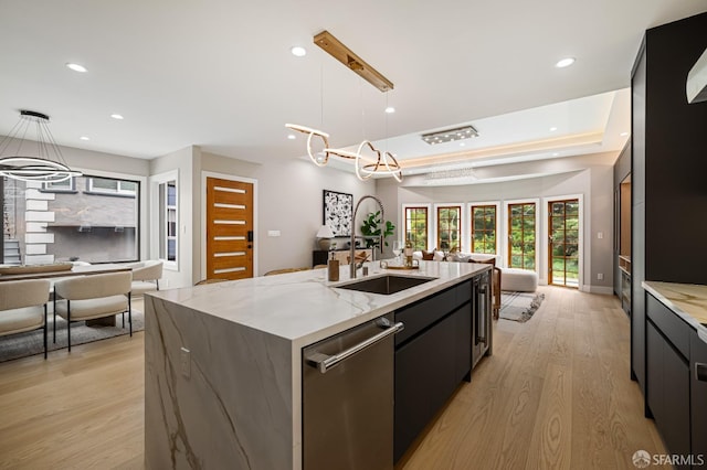 kitchen with open floor plan, a sink, modern cabinets, dishwasher, and a center island with sink