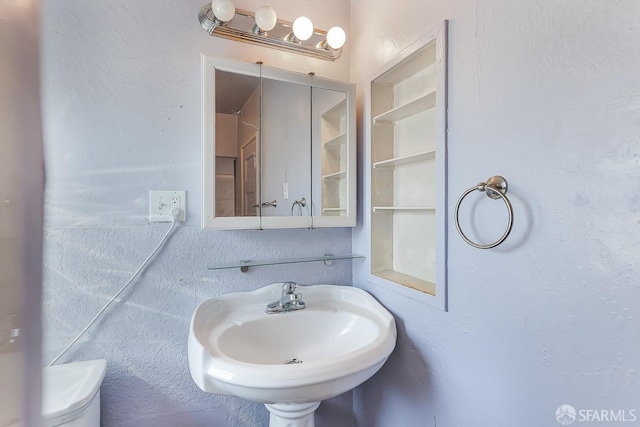 bathroom with a sink and a textured wall