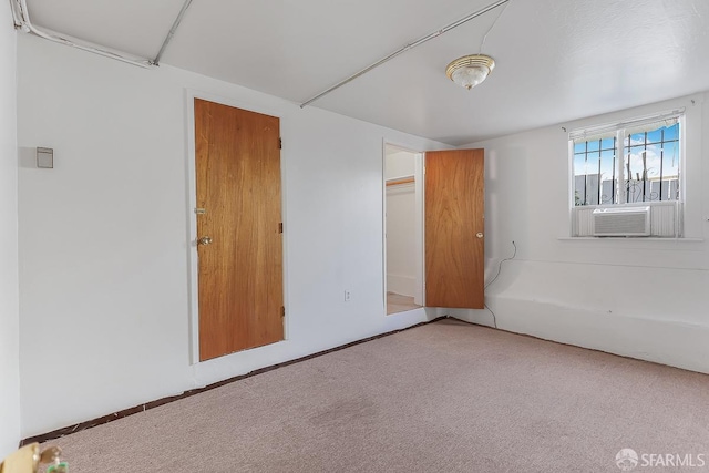 unfurnished room with cooling unit and carpet flooring