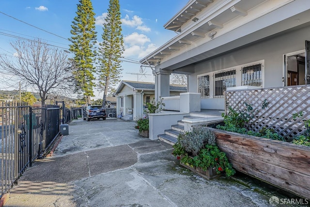 doorway to property with fence and stucco siding