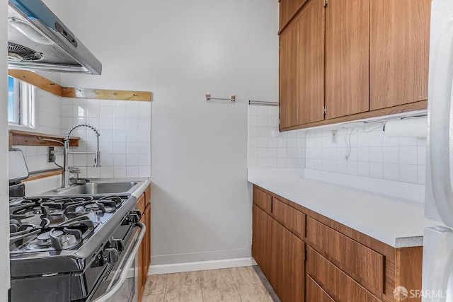 kitchen with brown cabinets, light countertops, extractor fan, and gas range