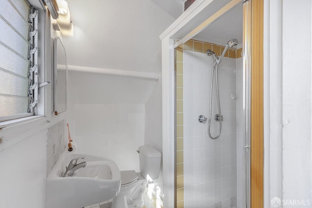 bathroom featuring a tile shower and toilet