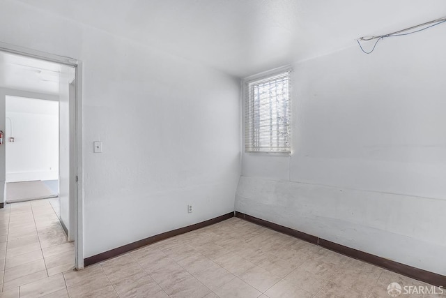 spare room with baseboards