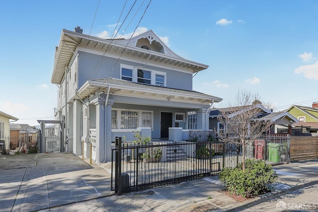 view of front of home with covered porch, a fenced front yard, and stucco siding