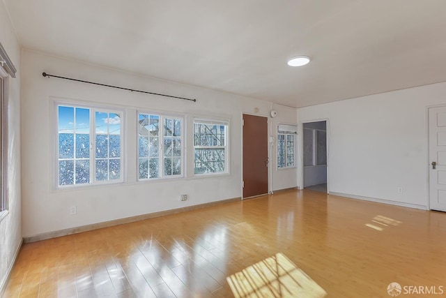 unfurnished room with light wood-style flooring and baseboards