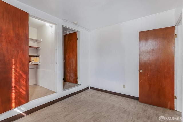 unfurnished room with baseboards