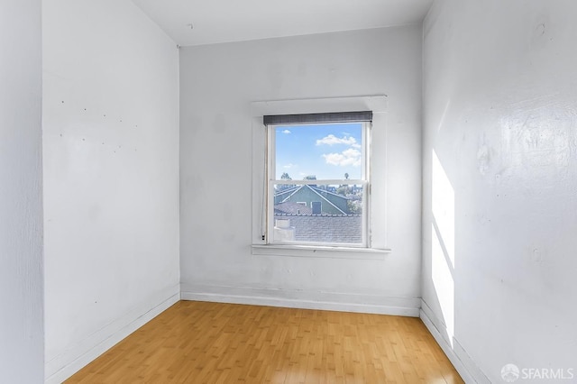 empty room with light wood-type flooring and baseboards