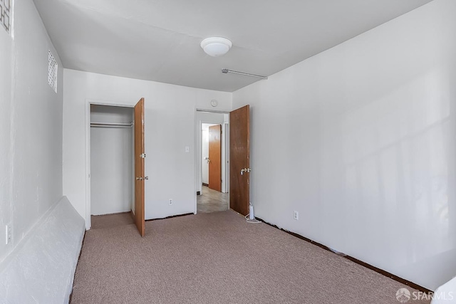 unfurnished bedroom with visible vents, a closet, and light colored carpet