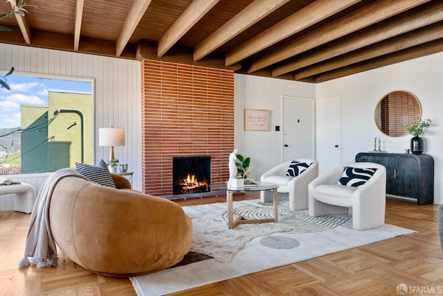 living room featuring beamed ceiling and a fireplace