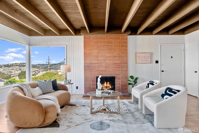 living room featuring a brick fireplace, wood ceiling, and beam ceiling