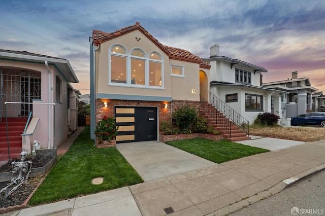 26 Southwood Dr, San Francisco, CA 94112 - mediterranean / spanish home with stucco siding, an attached garage, driveway, a yard, and brick siding