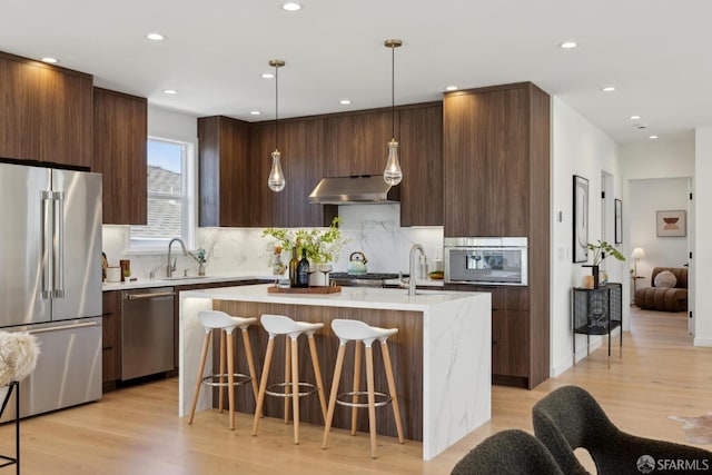 26 Southwood Dr, San Francisco, CA 94112 - kitchen with stainless steel appliances, modern cabinets, exhaust hood, an island with sink, and light countertops