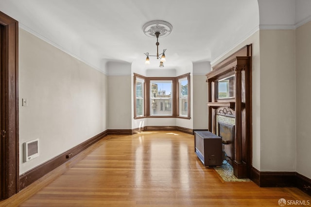 3340 24th St, San Francisco, CA 94110 - unfurnished dining area with wood finished floors, baseboards, a glass covered fireplace, and a chandelier