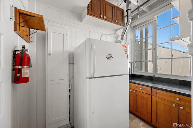 3340 24th St, San Francisco, CA 94110 - kitchen featuring freestanding refrigerator, dark countertops, and brown cabinetry