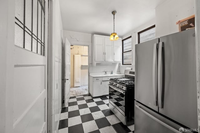 3340 24th St, San Francisco, CA 94110 - kitchen featuring stainless steel appliances, dark flooring, white cabinetry, light countertops, and backsplash
