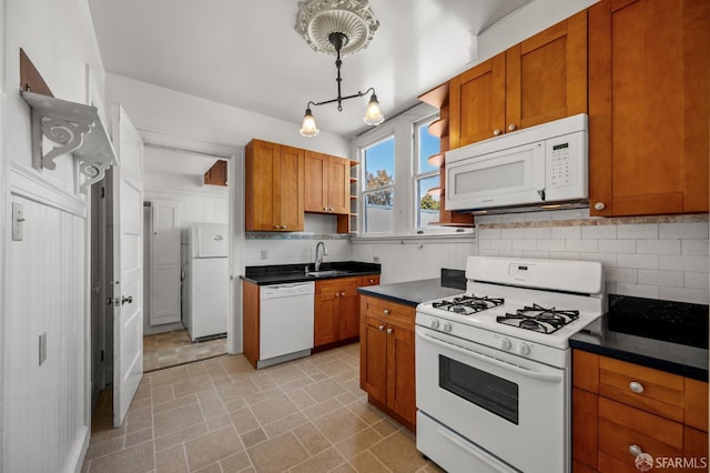 3340 24th St, San Francisco, CA 94110 - kitchen with white appliances, a sink, dark countertops, decorative backsplash, and brown cabinetry