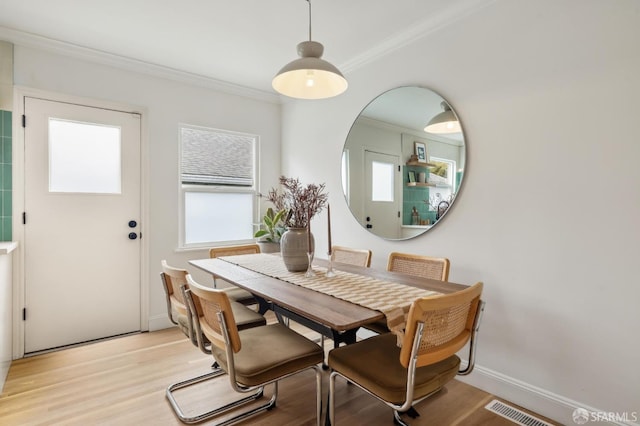 dining room featuring ornamental molding and light wood-type flooring