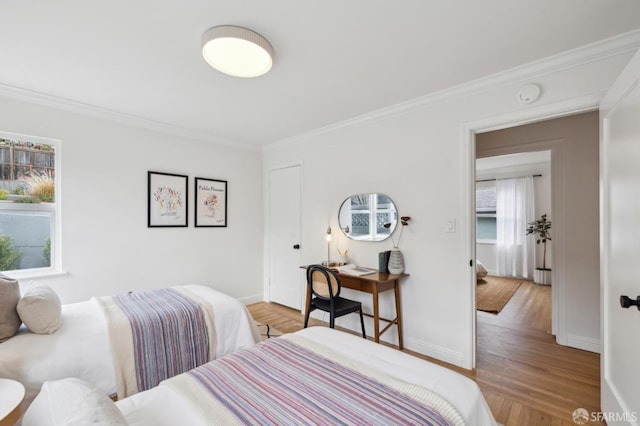 bedroom with crown molding, a closet, and light wood-type flooring