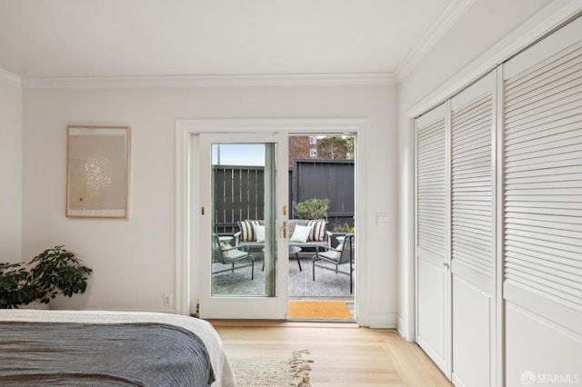 bedroom with light hardwood / wood-style flooring, crown molding, and access to outside