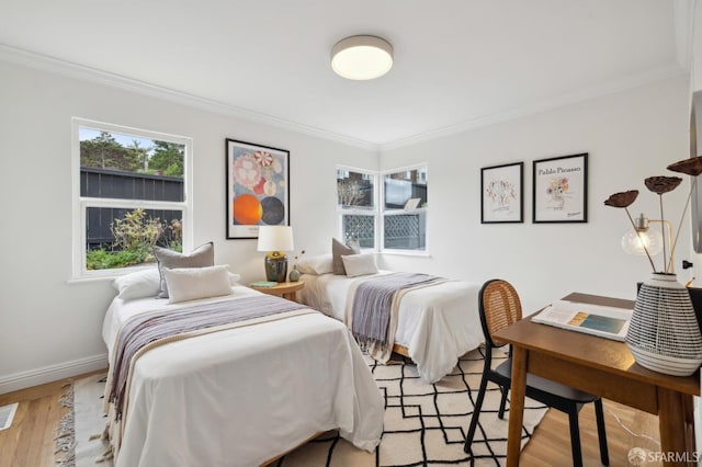 bedroom with ornamental molding and light hardwood / wood-style floors