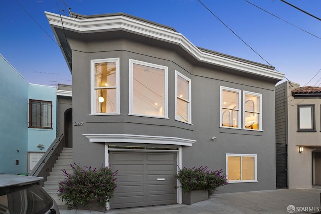 267 Bonview St, San Francisco, CA 94110 - view of front facade with stucco siding, a garage, and stairway