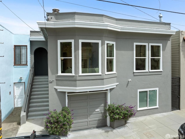 267 Bonview St, San Francisco, CA 94110 - view of front facade featuring stucco siding, an attached garage, and stairway