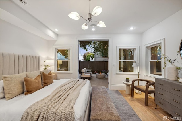 267 Bonview St, San Francisco, CA 94110 - bedroom with light wood-type flooring, a chandelier, access to exterior, and recessed lighting
