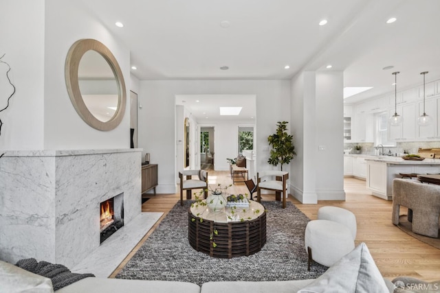 267 Bonview St, San Francisco, CA 94110 - living room with recessed lighting, light wood-type flooring, a high end fireplace, and a skylight