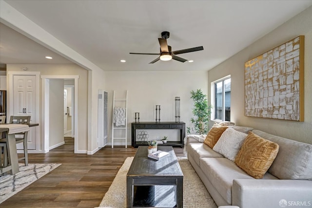 living room featuring ceiling fan and dark hardwood / wood-style floors