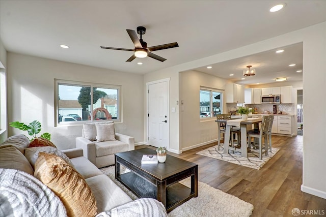 living room featuring hardwood / wood-style floors, ceiling fan, sink, and a wealth of natural light