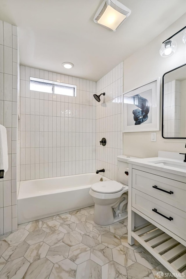 full bathroom featuring vanity, toilet, and tiled shower / bath