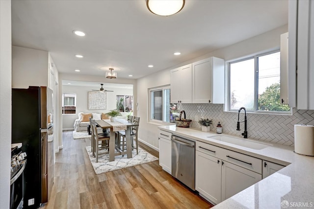 kitchen featuring tasteful backsplash, sink, white cabinets, and appliances with stainless steel finishes