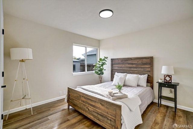 bedroom with dark hardwood / wood-style floors