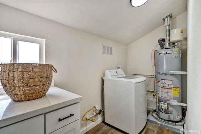 clothes washing area with secured water heater, dark hardwood / wood-style flooring, cabinets, and washer / dryer