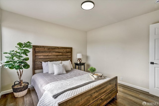 bedroom with dark hardwood / wood-style floors