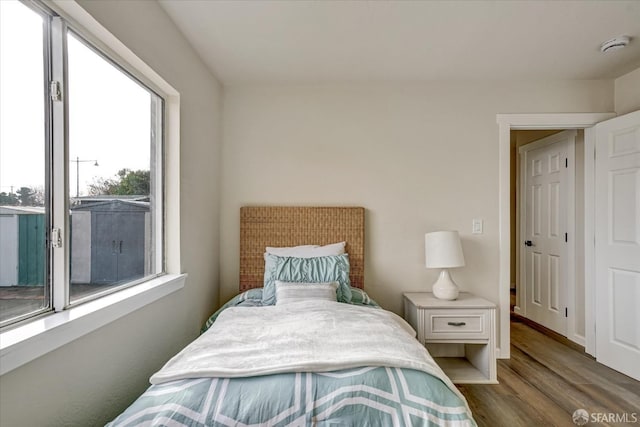 bedroom with dark wood-type flooring and multiple windows